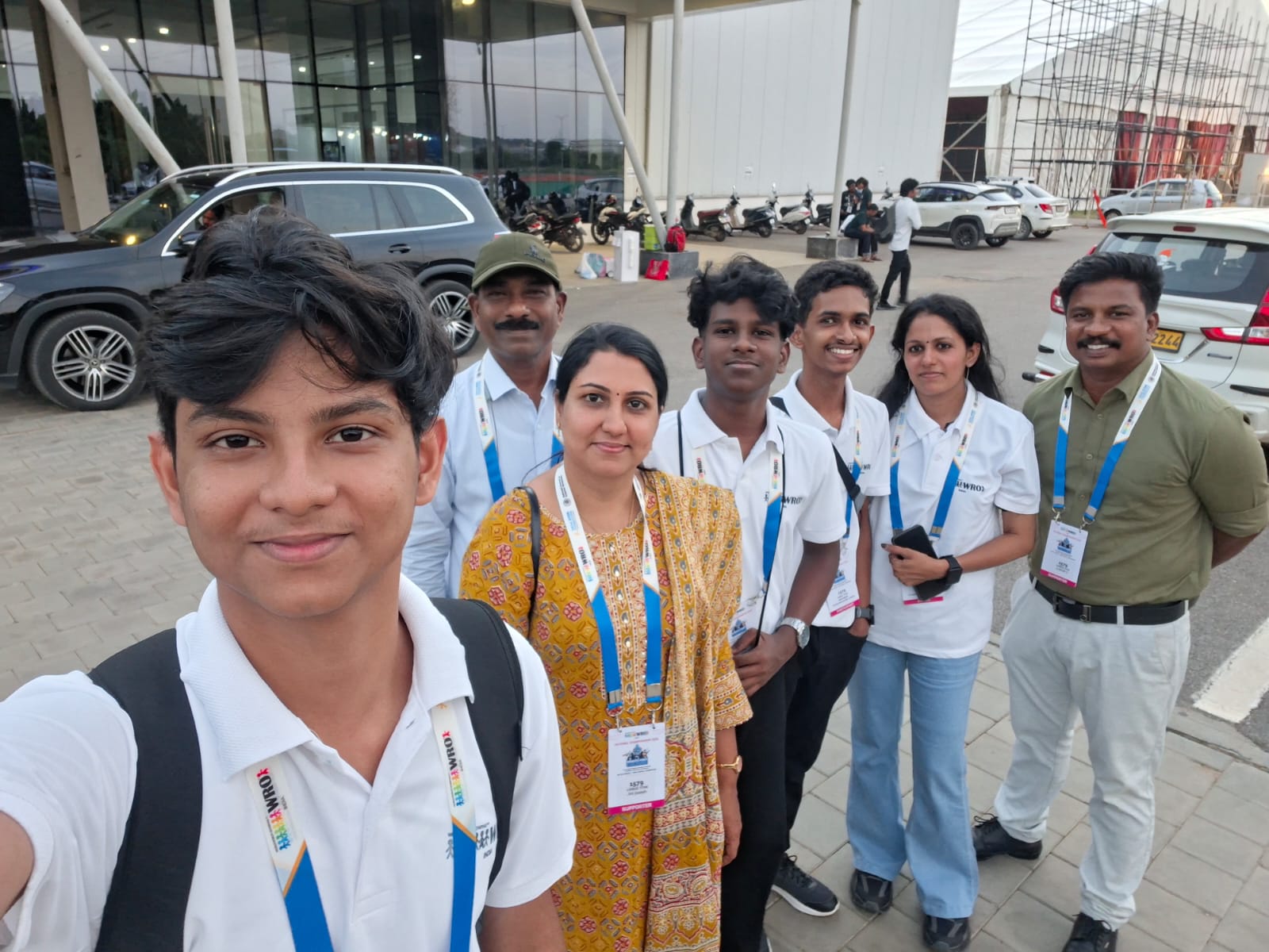 Lisieux Titan outside GMR Arena, Hyderabad. Francis Joseph takes the selfie in front; behind him are Baiju R (Goutham B's father) in a cap, Jini Joseph (Francis's mother), Goutham B, Gautham R, mentor Divya M U and supporter Ajeesh A in a green shirt.